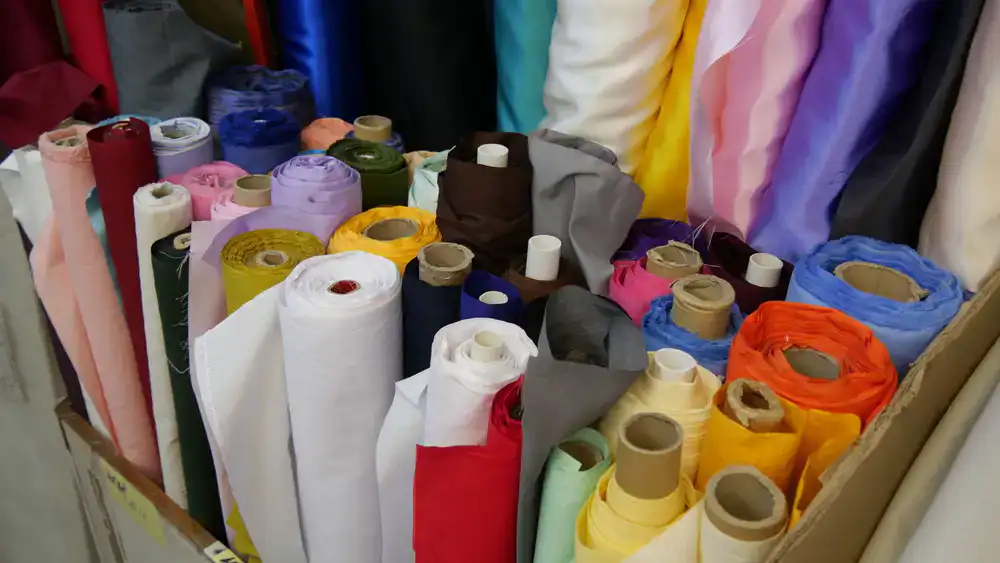 Colorful fabric rolls stacked neatly on a shop shelf
